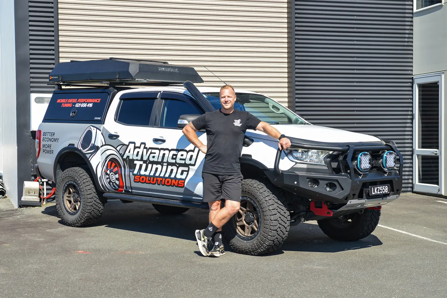 Advanced Tuning Solutions technician standing beside tuned Ford Ranger outside work-site