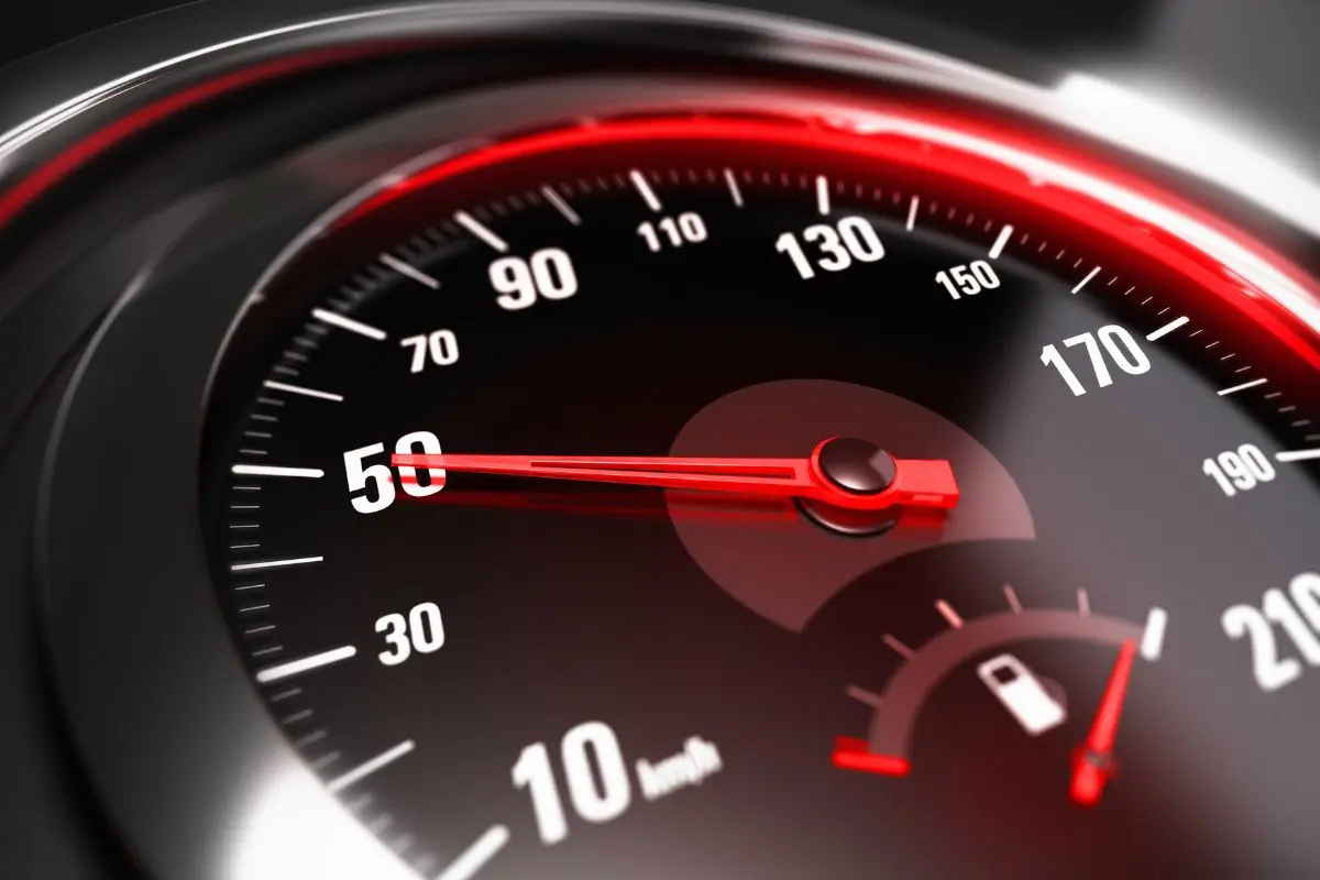 Vehicle speedometer with red illuminated needle showing increased performance potential from ECU tuning